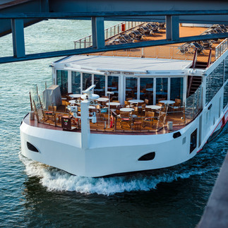 River vessel sailing under bridge.
