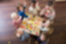 An overhead view of a multiracial group of six preschoolers sitting with their teacher at