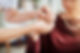 A nurse holding an elderly woman's hands in a nursing home