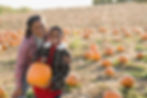 A lady and child enjoying time together at a pumpkin farm during a The Newberry Institute community program.