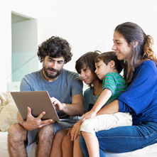 Familia reunida entre pantallas y dispositivos digitales que representan la convivencia en la era de la inteligencia artificial.