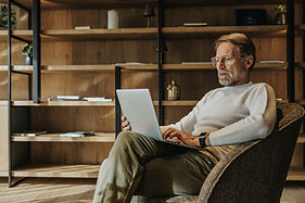 Bejaarde man die aan laptop werkt