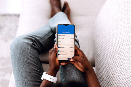 Person holding a phone with a digital banking app open