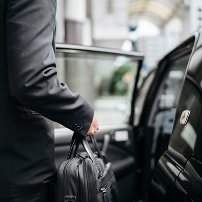 a businessman getting into a taxi
