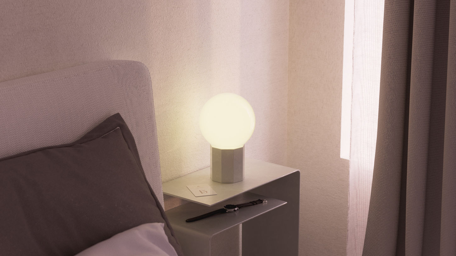 Spherical lamp on a minimalist bedside table.