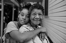 Granddaughter embracing grandmother outdoors
