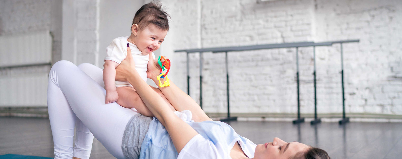 Mom holding a baby while performing some pelvic floor exercises.