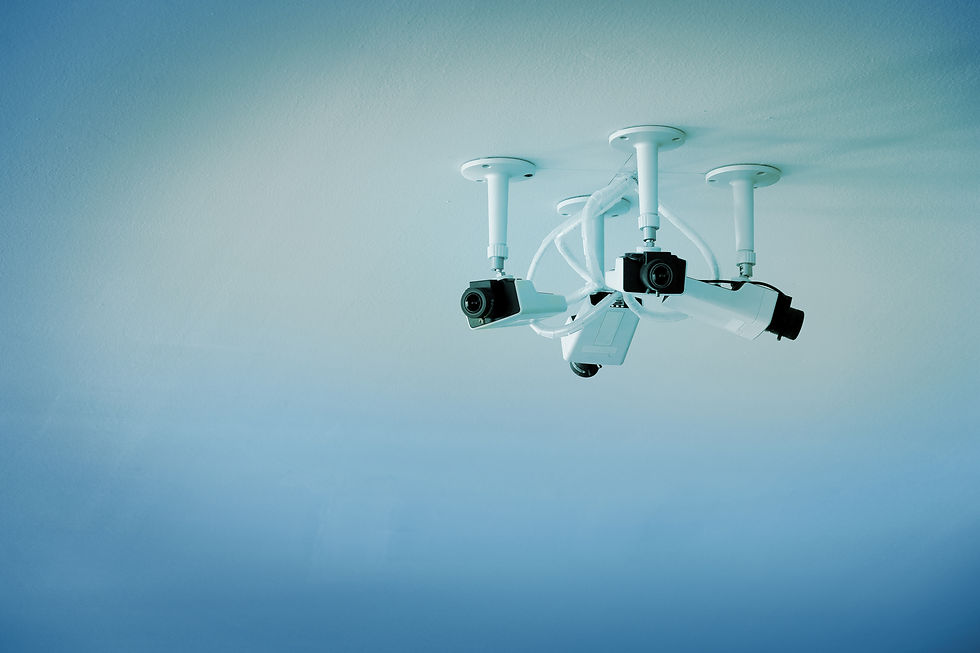 Three security cameras are mounted on a ceiling