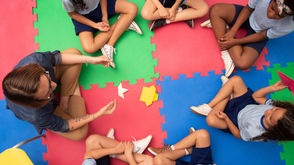 Menschen sitzen im Kreis und diskutieren gemeinsam – Symbolbild für Neurodiversität im Arbeitsalltag sowie den wertschätzenden Umgang mit unterschiedlichen Denk- und Wahrnehmungsweisen.