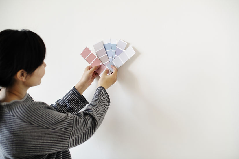 Person holding interior paint colour swatches for home design selection
