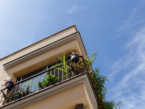 Fachada de una vivienda en Valencia con balcón y vegetación