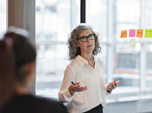 Business leader presenting strategy ideas on sticky notes in a workshop setting