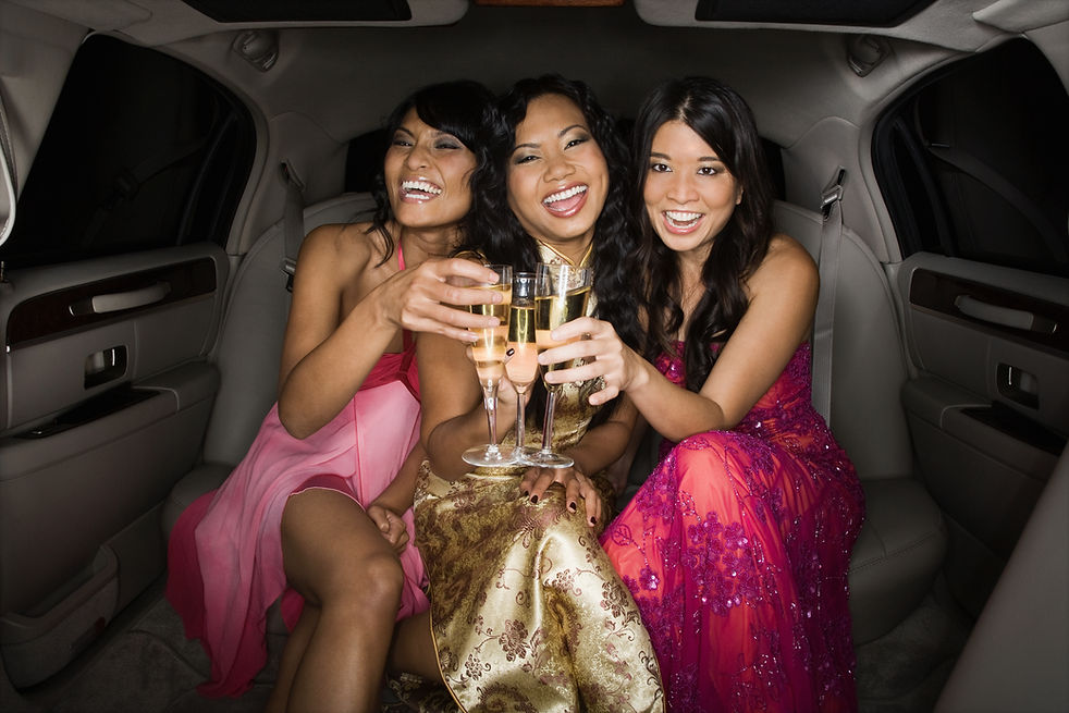 Multi-ethnic women toasting in limousine