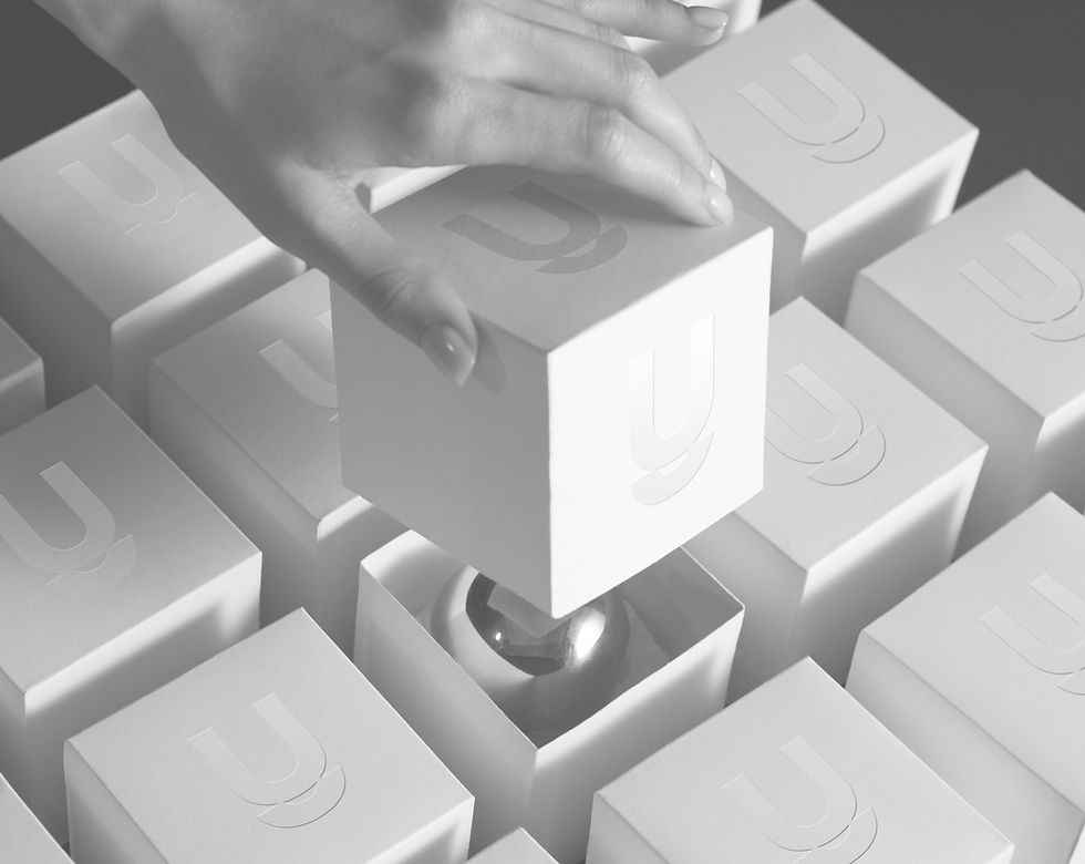 Mão segurando um cubo branco