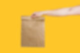 Male hand holding eco craft takeout food bag