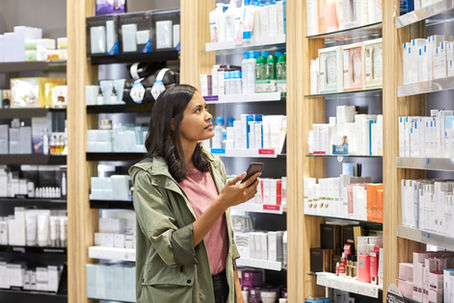 Cliente combinando compra en tienda con app móvil para una experiencia híbrida.