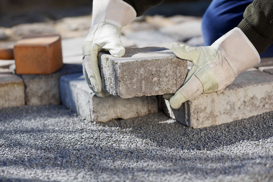 Close up shit of construction worker paving the brick road