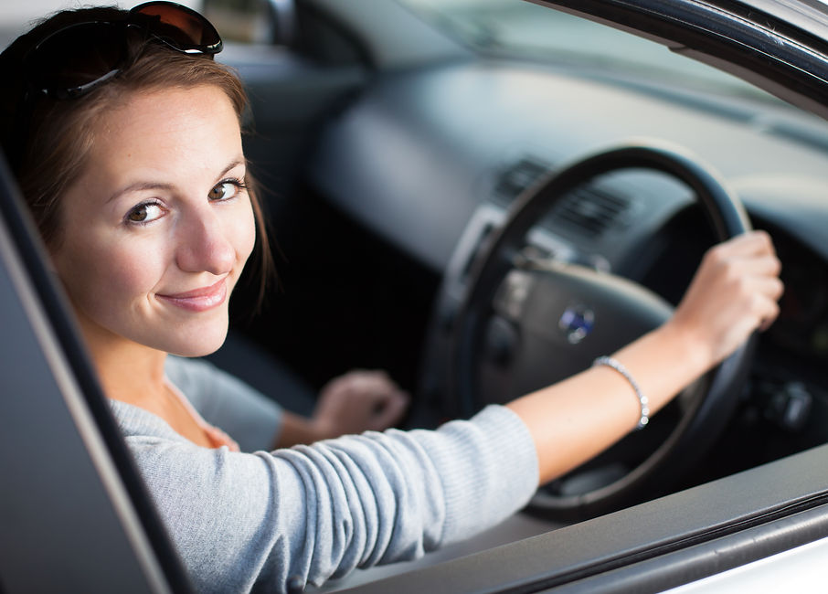 View of a young woman smiling inside the car