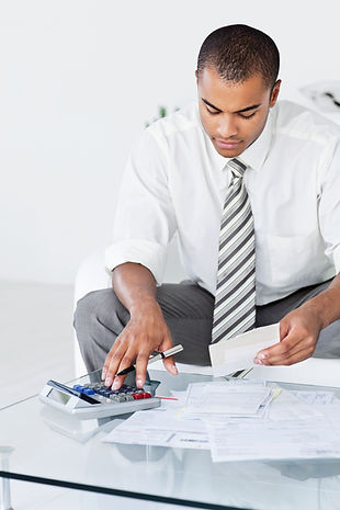 A person calculates expenses with a calculator and examines bills