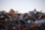 Large heap of rusty and dark scrap metal at a garbage dump pile