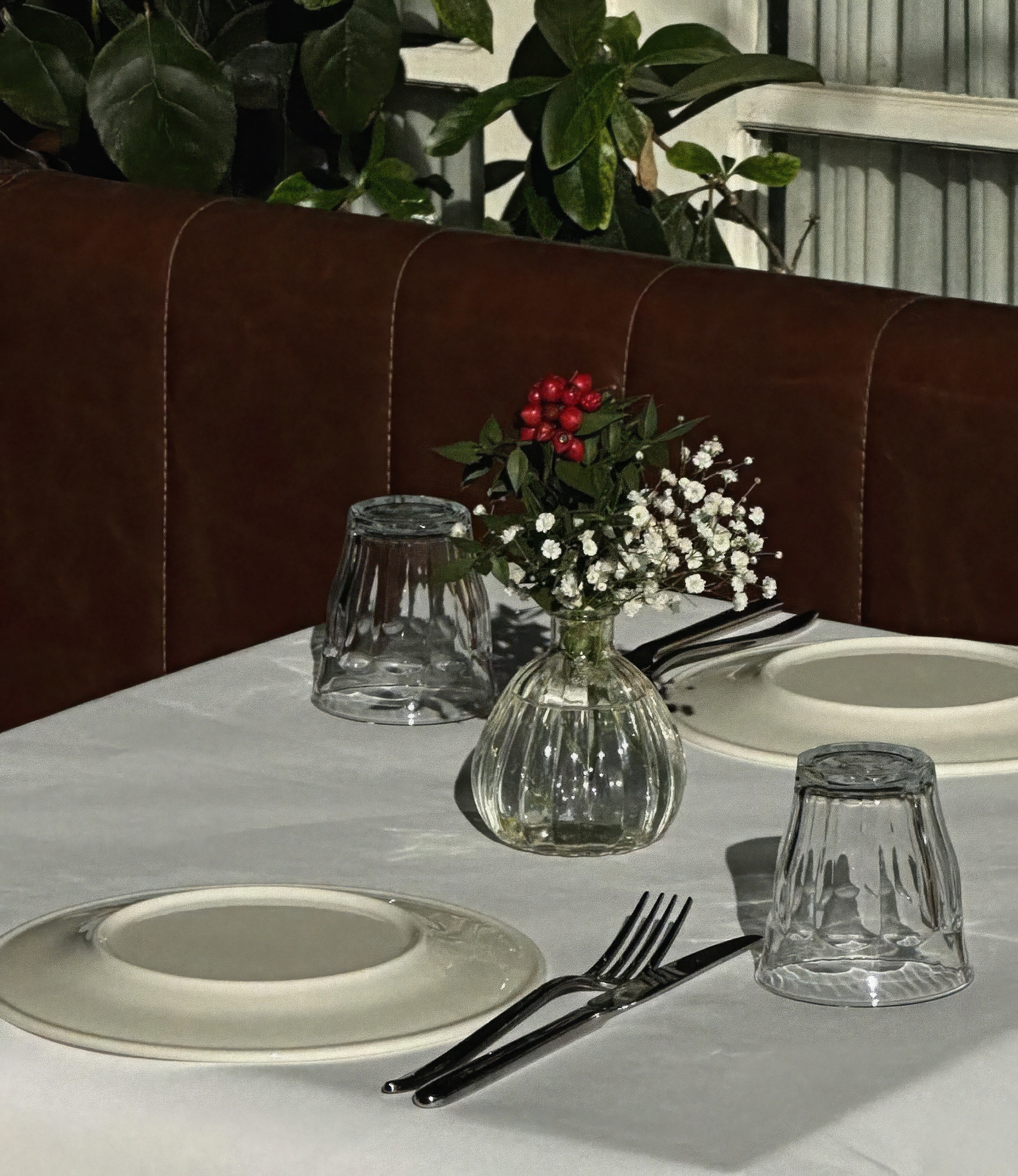 Warm restaurant dining room prepared for guests with polished tables and inviting ambient lighting