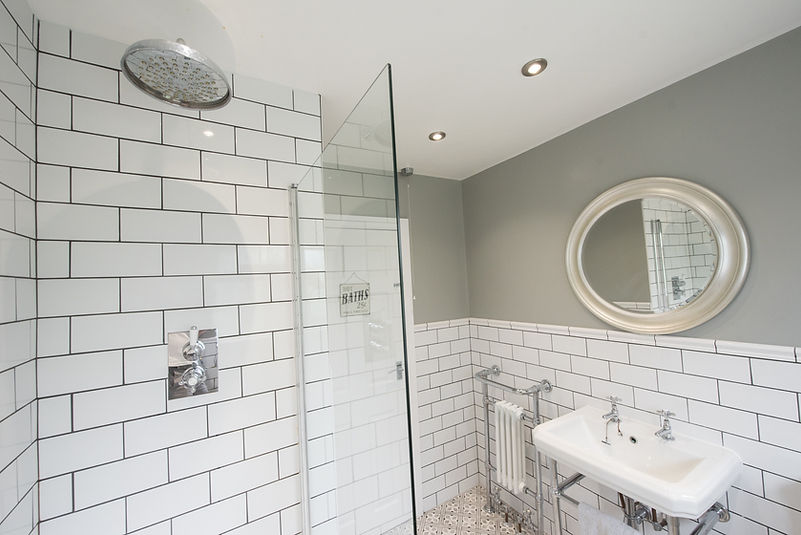 A general view of a white tiled, grey walled old styled bathroom