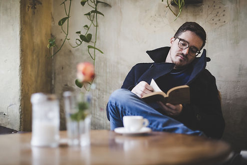 A man reading a book while having a cup of coffee