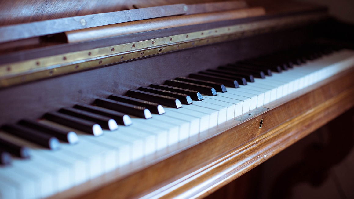 Close-up of a vintage wooden piano keyboard, focusing on black