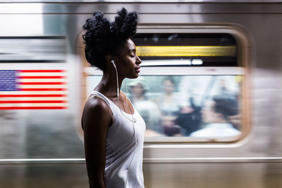 Image of a lady on the subway listening to the radio through her earphones