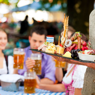 Guests dressed in traditional German attire enjoying a lively atmosphere at a Southwest Minnesota brewery, celebrating with craft beer and community spirit.