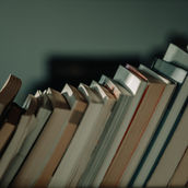 Mensola con libri di diversi colori, metafora dei ruoli che compongono l'identità.