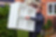 Man carrying a white shelving unit outside a house