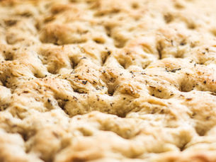 Freshly baked smoked garlic and smoked onion focaccia bread with a golden, crispy crust, topped with a savory smoked garlic, onions and a sprinkle of herbs