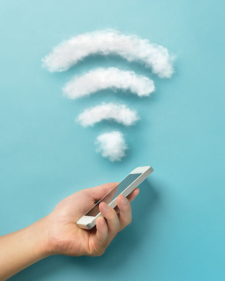 Hand holding smartphone next to floating cloud WiFi symbol