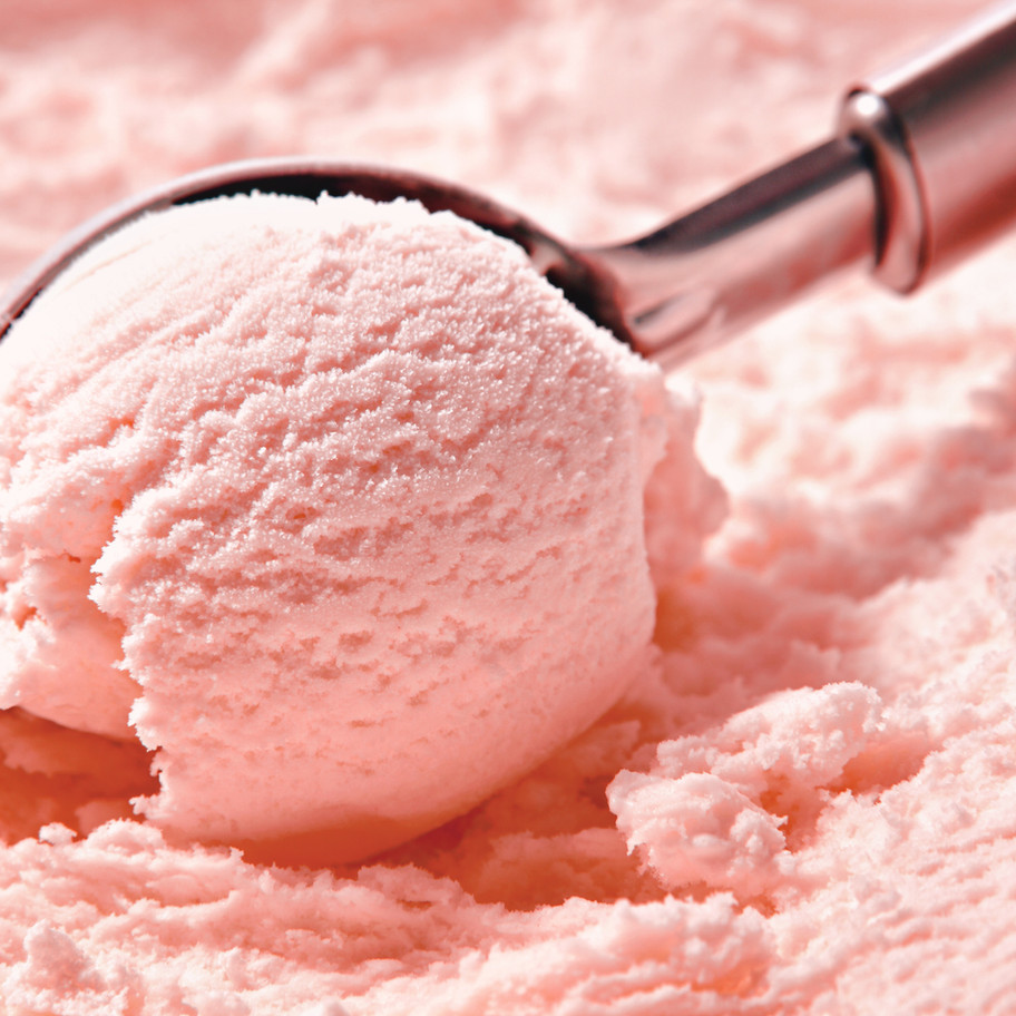 Strawberry ice cream scoop on a metal spoon