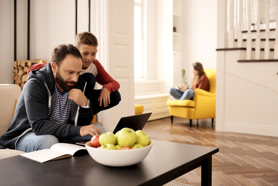 Un père consulte un site internet pour l'hypnose afin de prendre rendez-vous. Il montre son soutien à son enfant.