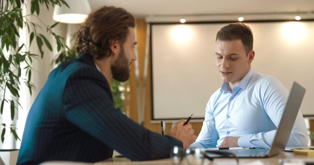 An employee and manager sitting together in a private meeting, discussing workplace adjustments and a return-to-work plan.