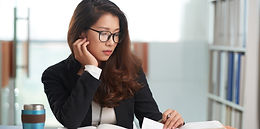 Vietnamese female law student reading a book and taking notes
