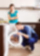 Housewife watching as worker repairing washing machine