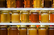 Locally-sourced, organic, raw honey in jars on shelves.