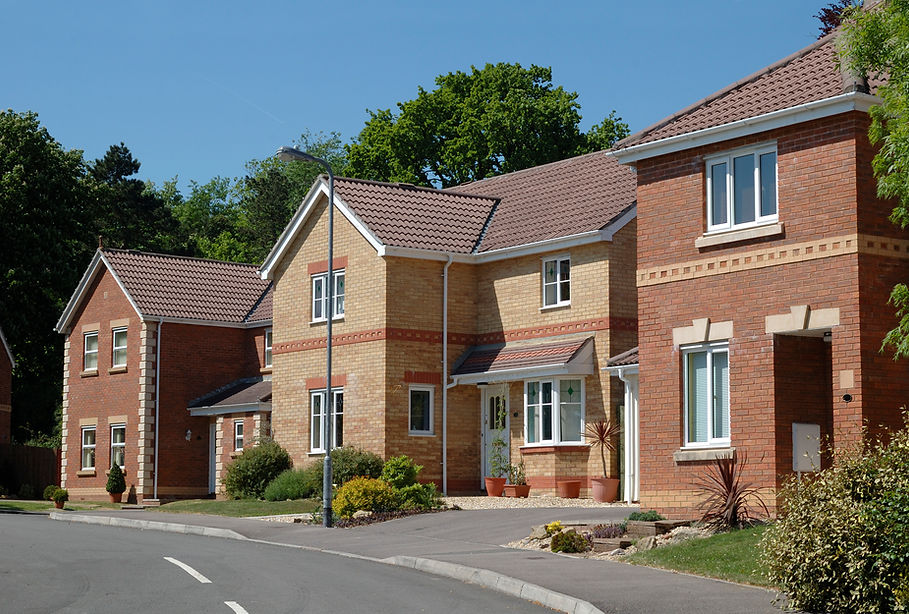 A row of modern suburban houses with brick and beige exteriors