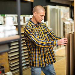 Man selects wood samples at store