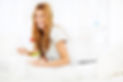 Cheerful young woman sitting in bed and eating healthy food for breakfast
