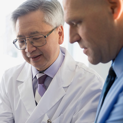 Male doctor checking a man's wrist