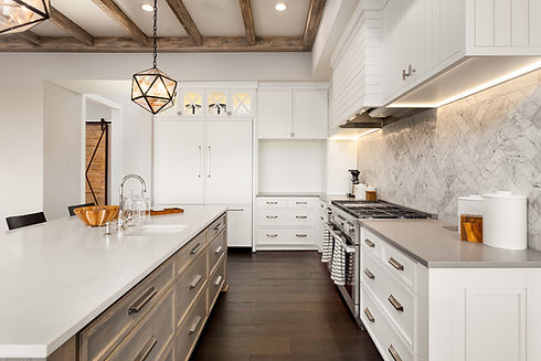 A kitchen with white wooden cabinetry and a modern chandelier