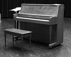 upright piano moving from a stage