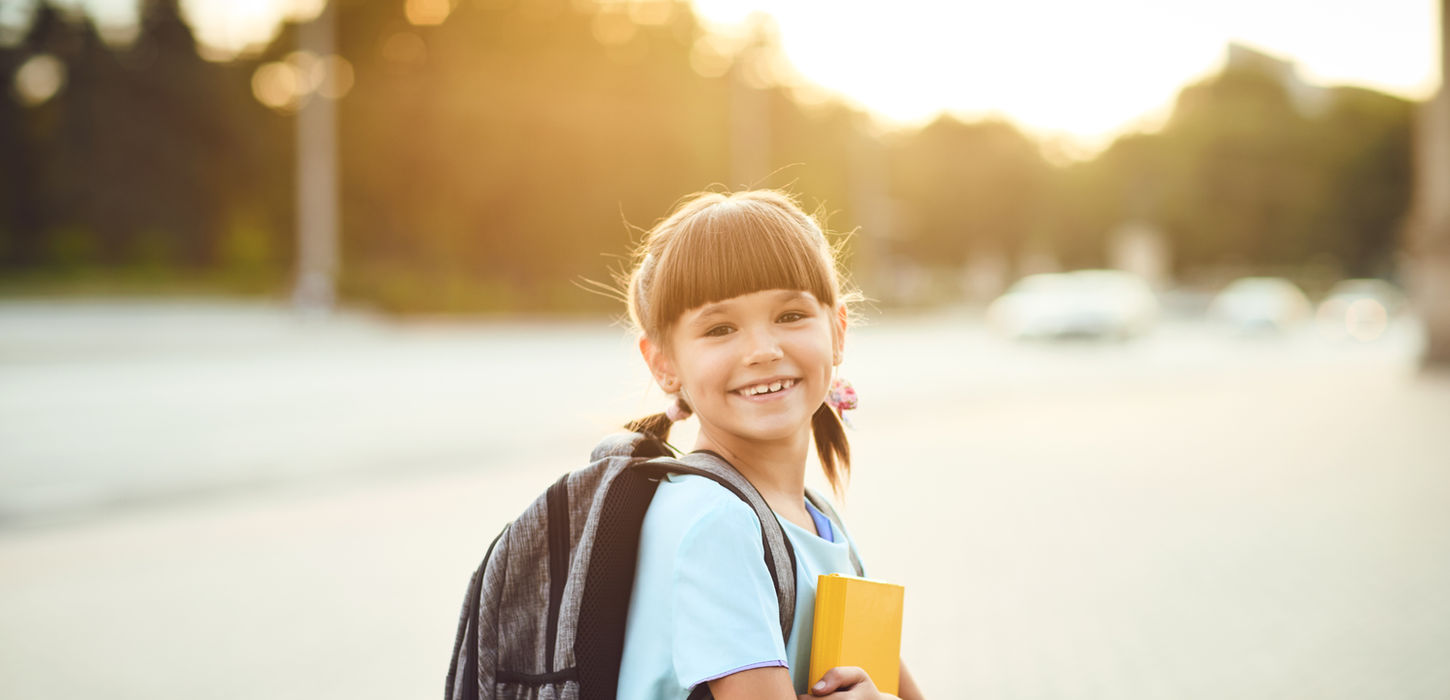 a girl smiling with a backpack on