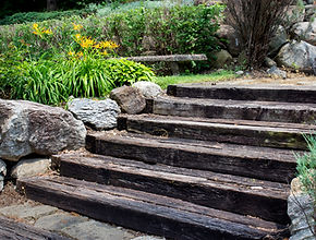 wooden stairs boarded by boulders and golden flowers