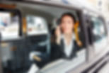 Business woman using a smart phone in a taxi