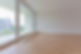 Empty room with large glass doors and newly fitted timber flooring